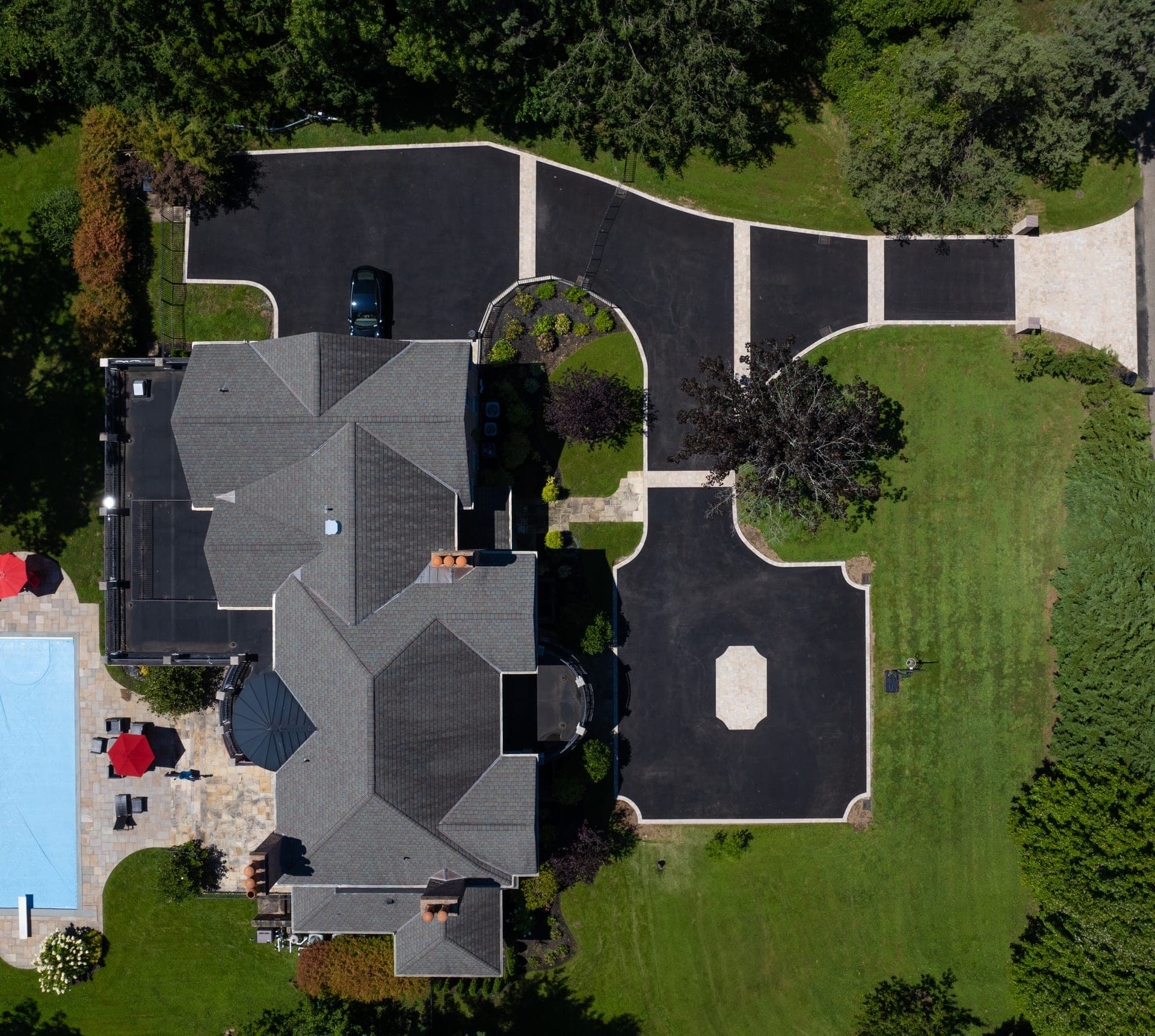 Overhead drone shot of full T-shaped estate driveway system with paver borders in Lloyd Harbor