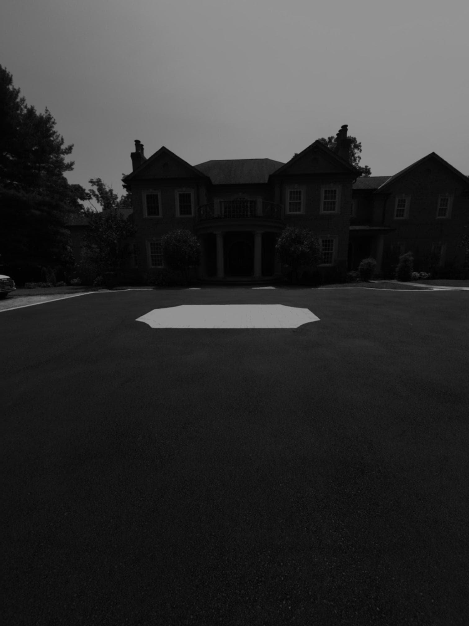 Paver medallion detail view with estate facade in Lloyd Harbor