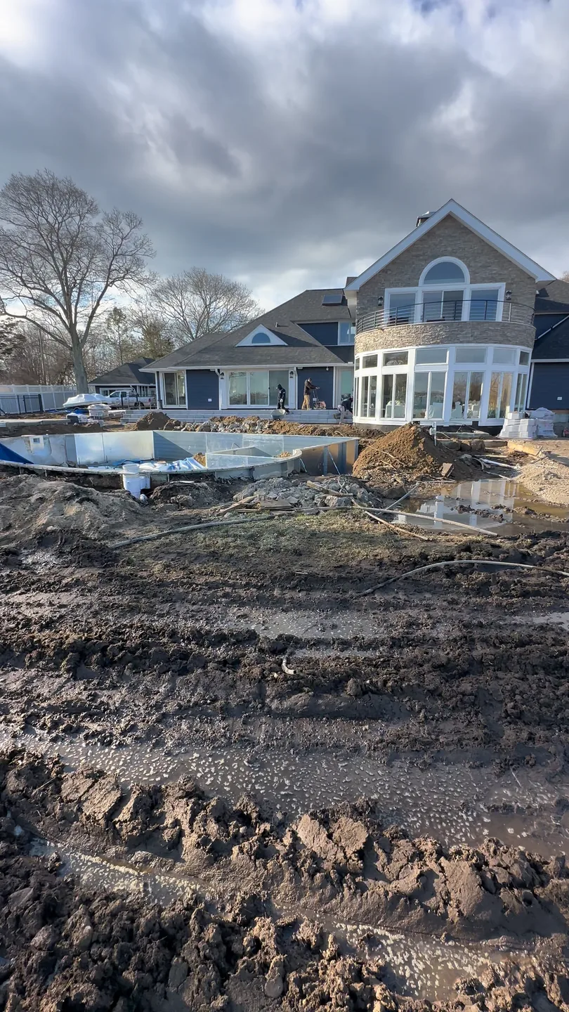 The rear yard stripped to winter mud with the house behind, Great River