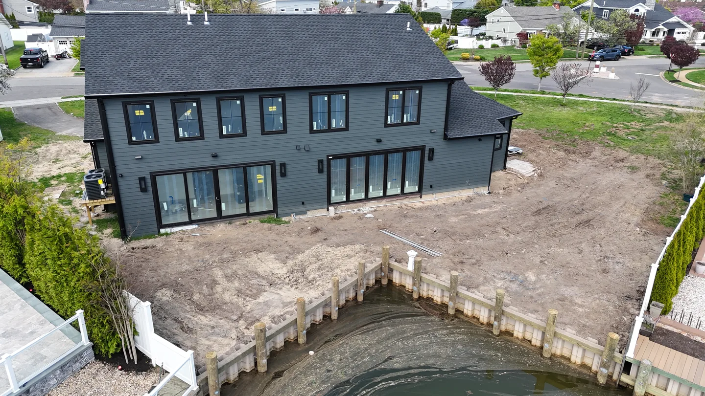 The stripped rear yard against the canal bulkhead before any hardscape, Massapequa