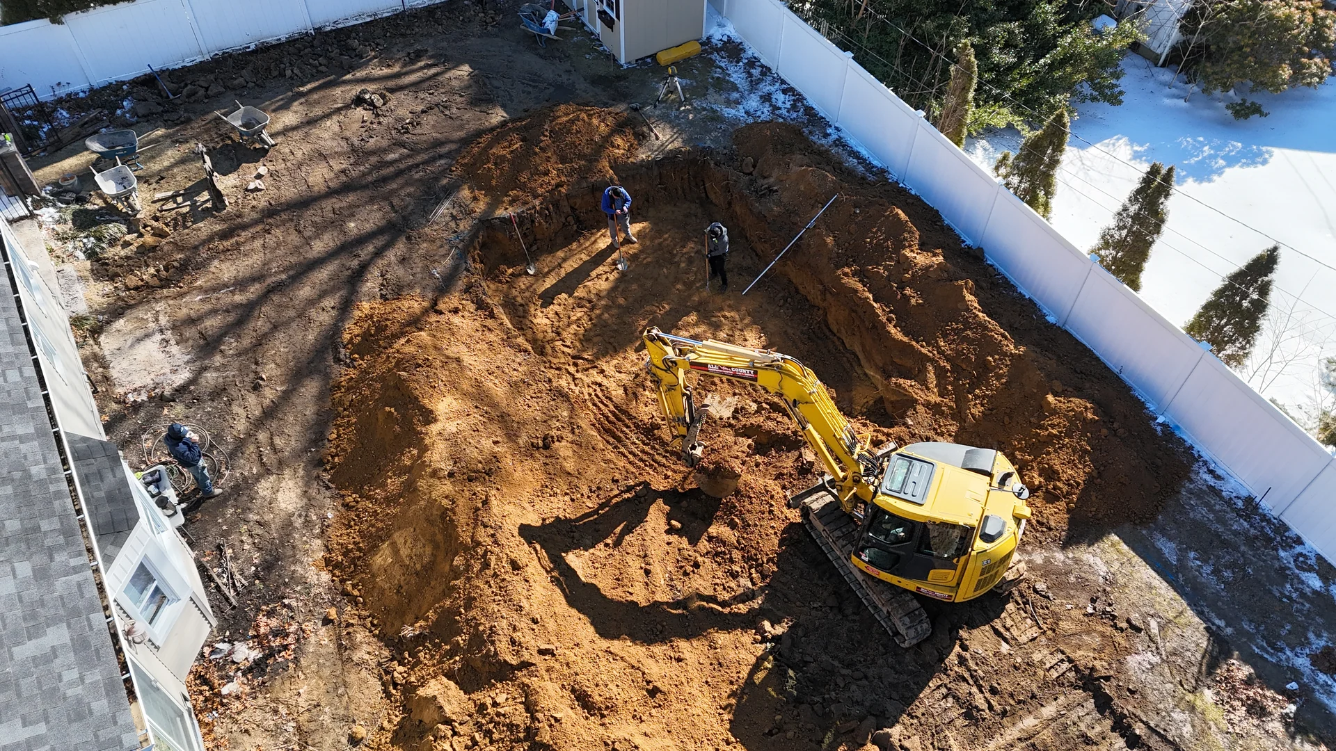 Brothers Paving & Masonry crew and excavator working the Nesconset site in winter