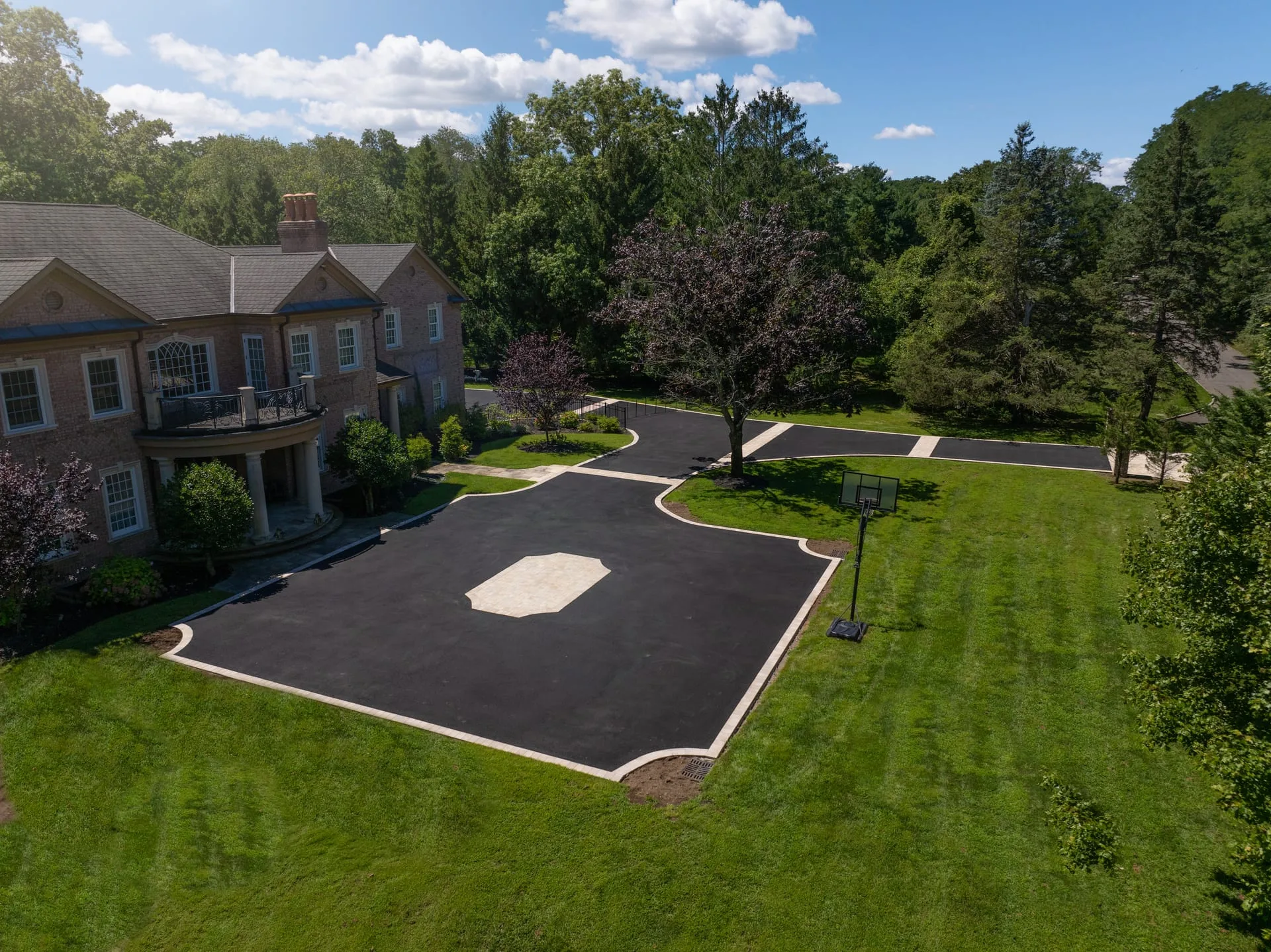 Drone aerial of completed Gold Coast estate driveway with paver medallion in Lloyd Harbor, NY