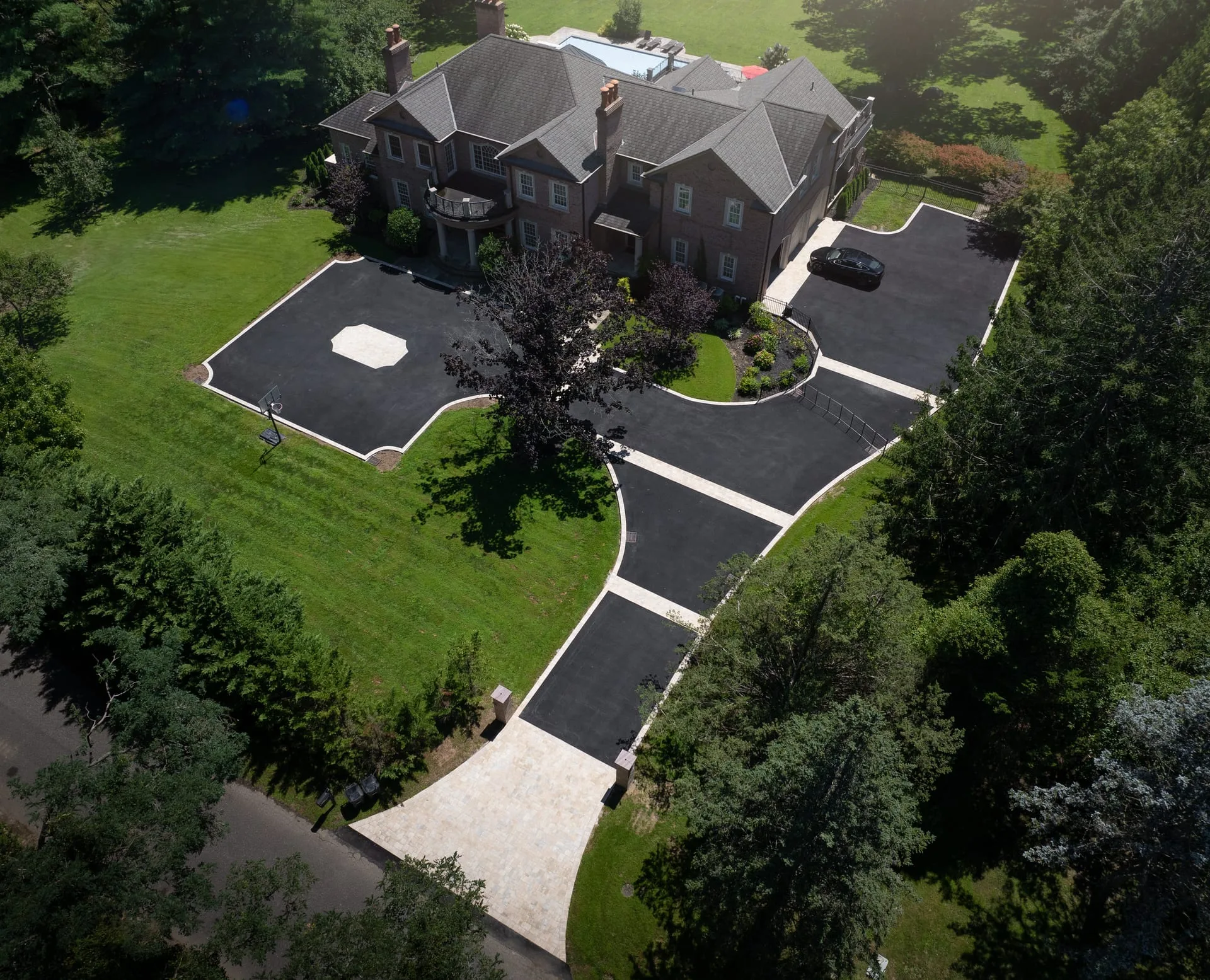 Aerial view of grand estate driveway approach with paver borders and medallion in Lloyd Harbor