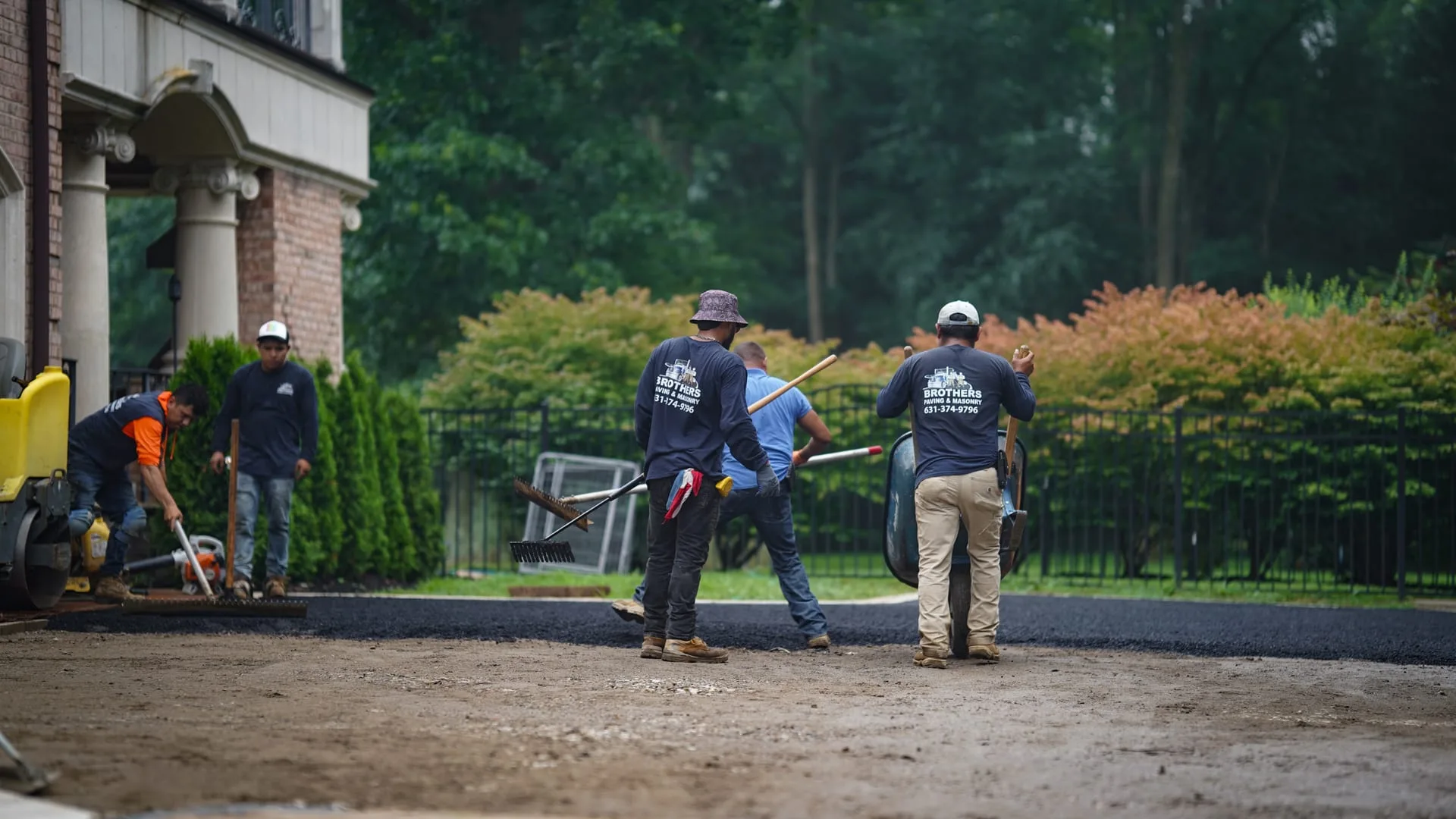 Wide view of freshly paved estate driveway with paver borders in Lloyd Harbor