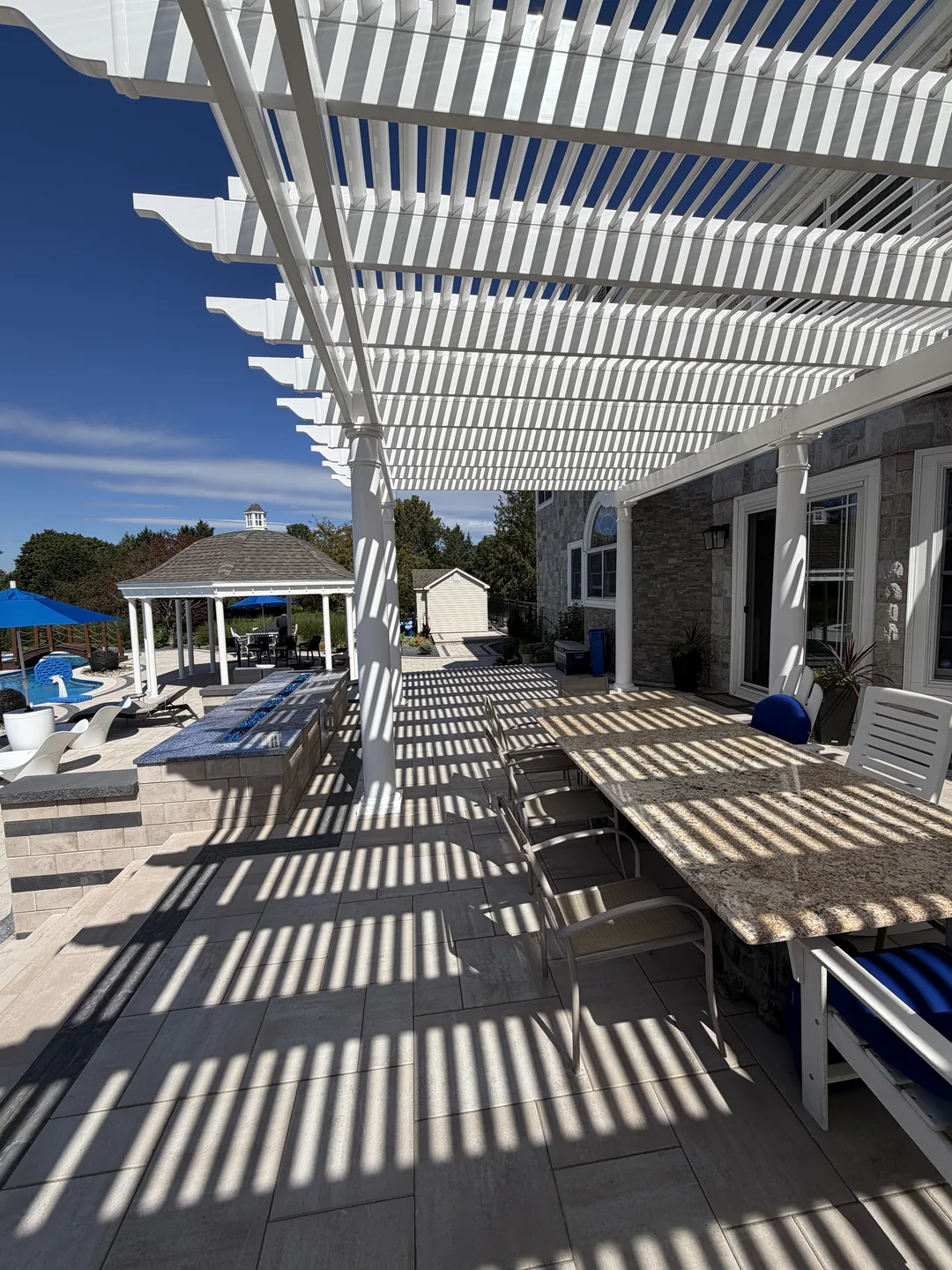 Dining set under the pergola with shadow detail, East Northport