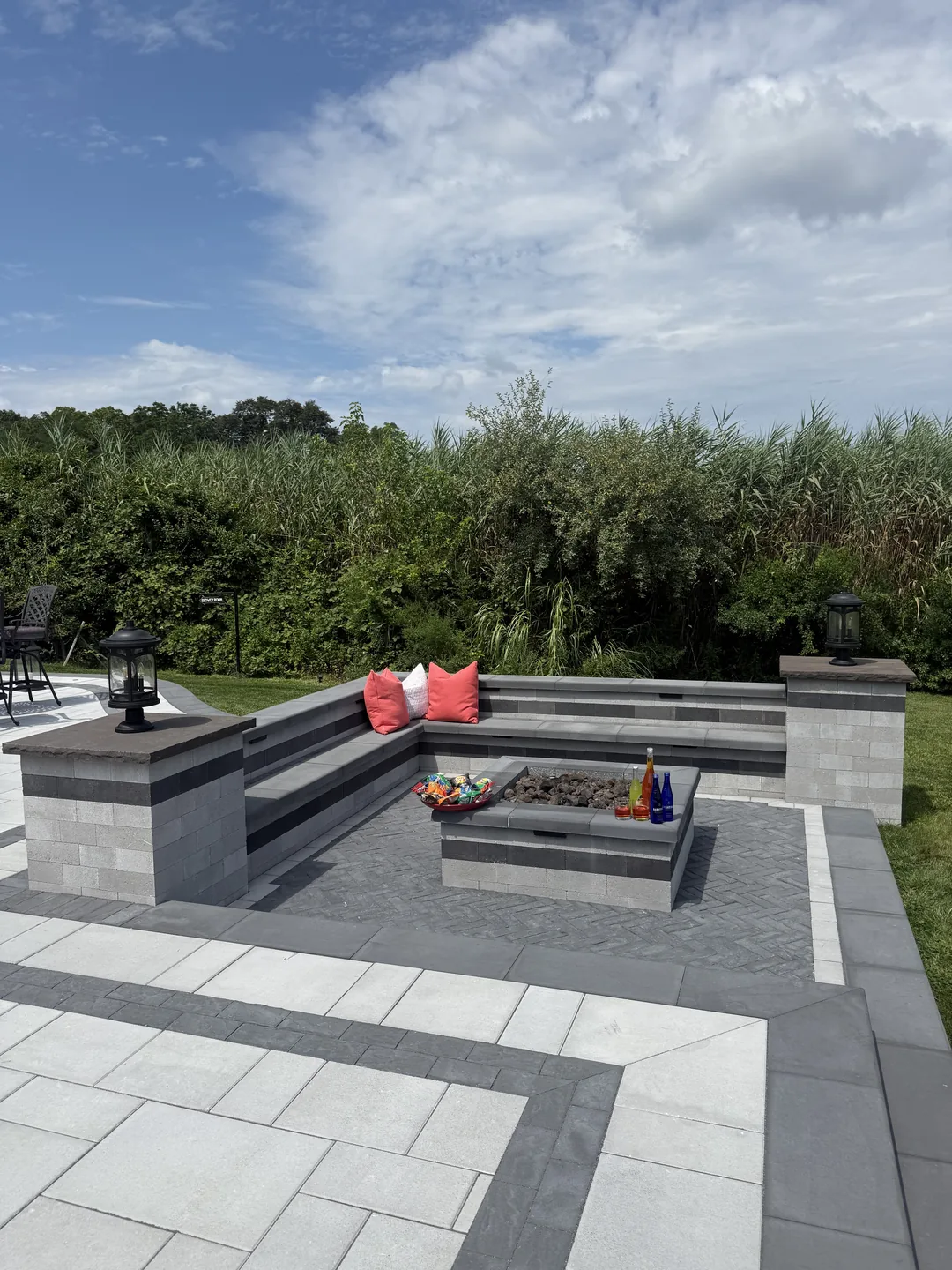 Fire pit lounge with seat walls and cushions on the finished paver deck, Great River