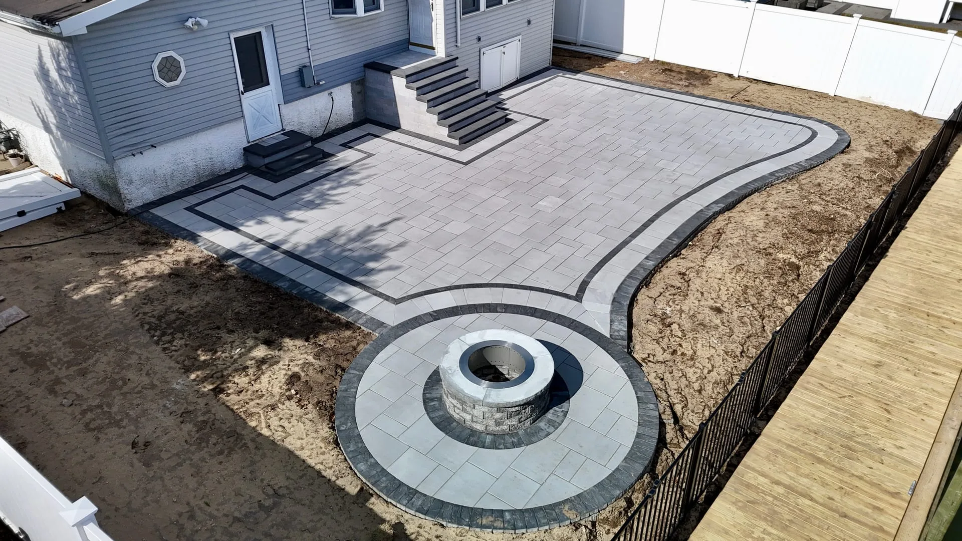 Completed backyard paver patio with seating wall in Huntington, Long Island