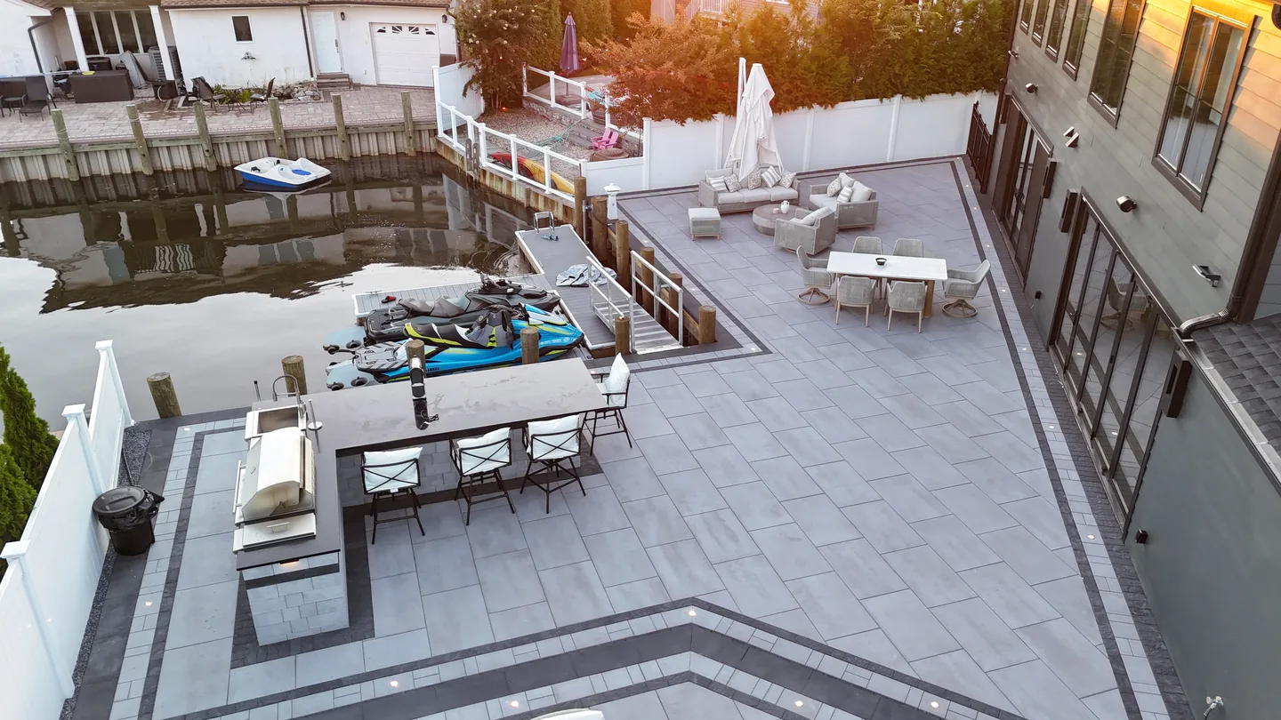 Dusk aerial showing the kitchen, umbrellas and lounge seating, Massapequa