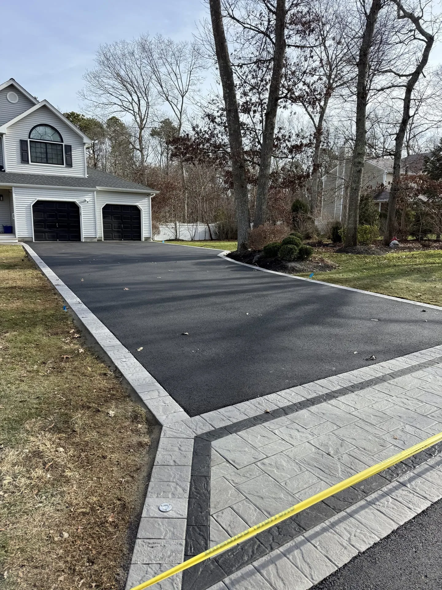 Grand paver driveway with Belgian block border approaching estate