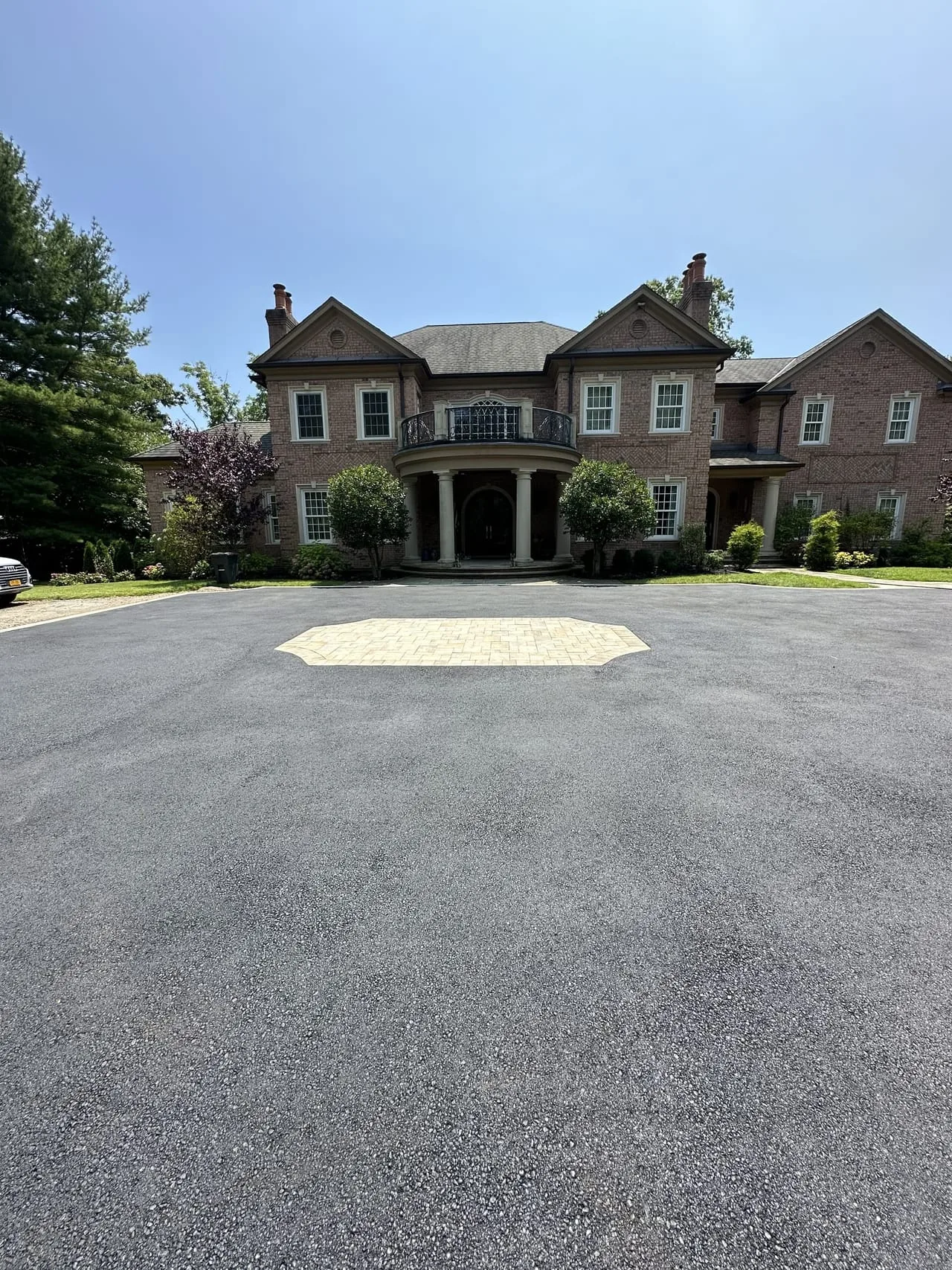 Paver medallion detail view with estate facade in Lloyd Harbor