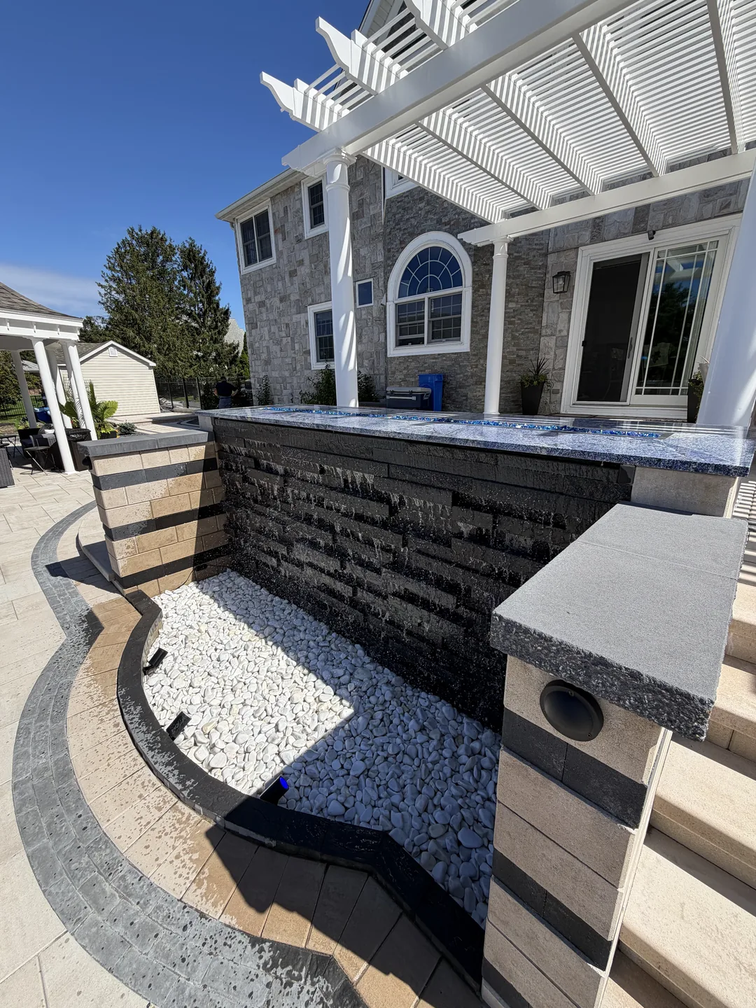 Banded stone veneer wall with water feature basin, East Northport