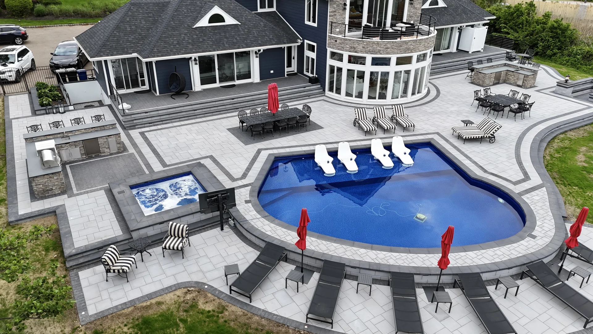 Aerial of the finished pool, raised spa and outdoor kitchen in Great River, Long Island
