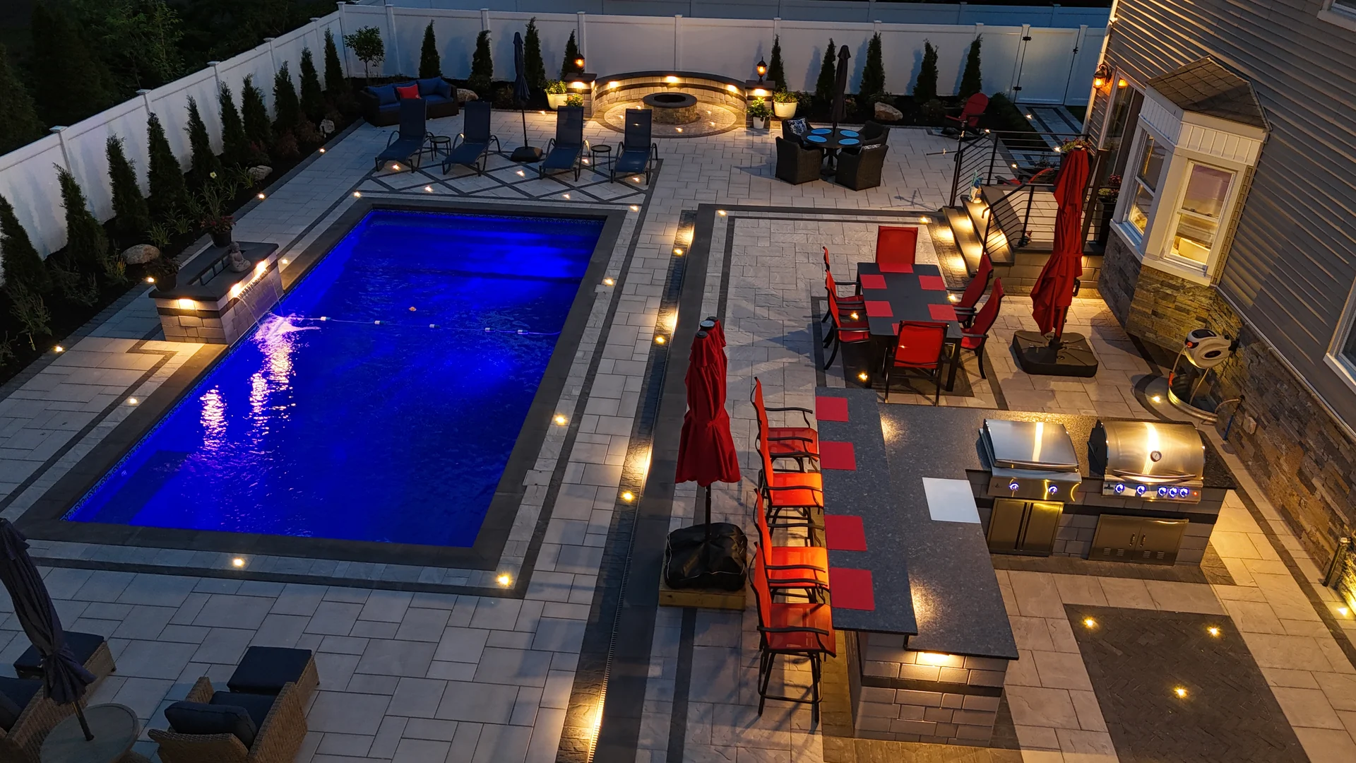 Aerial showing the kitchen and pool deck lit at dusk, Nesconset