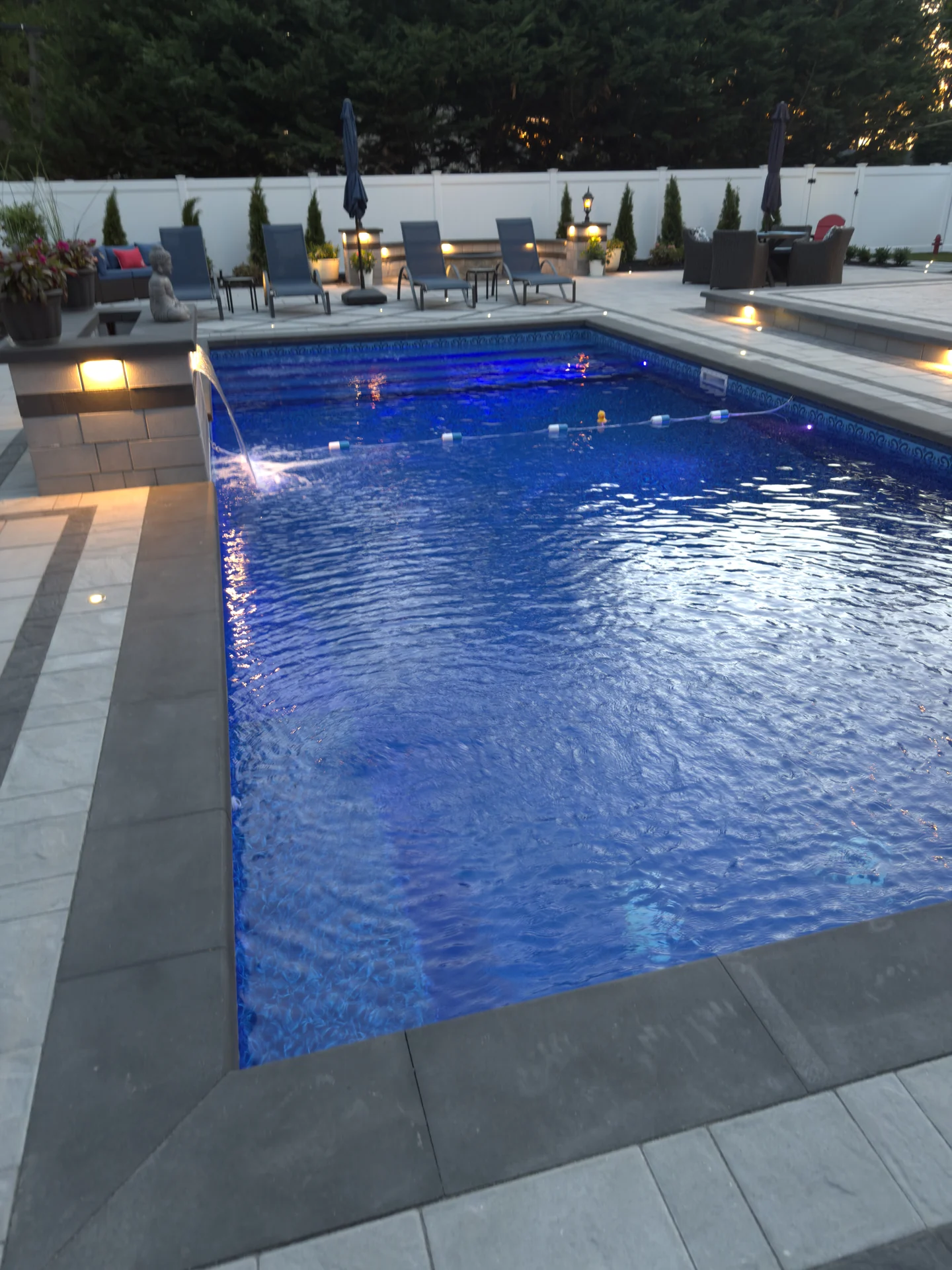 The pool lit from within at dusk, Nesconset