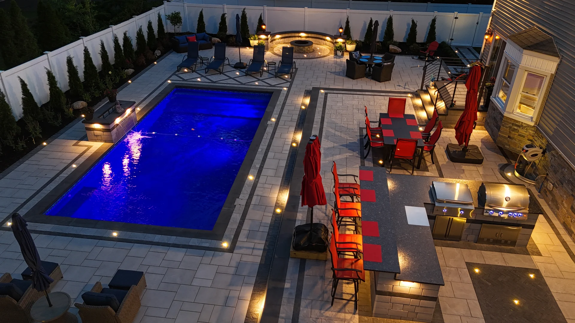 Aerial across the pool and fire terrace at dusk, Nesconset