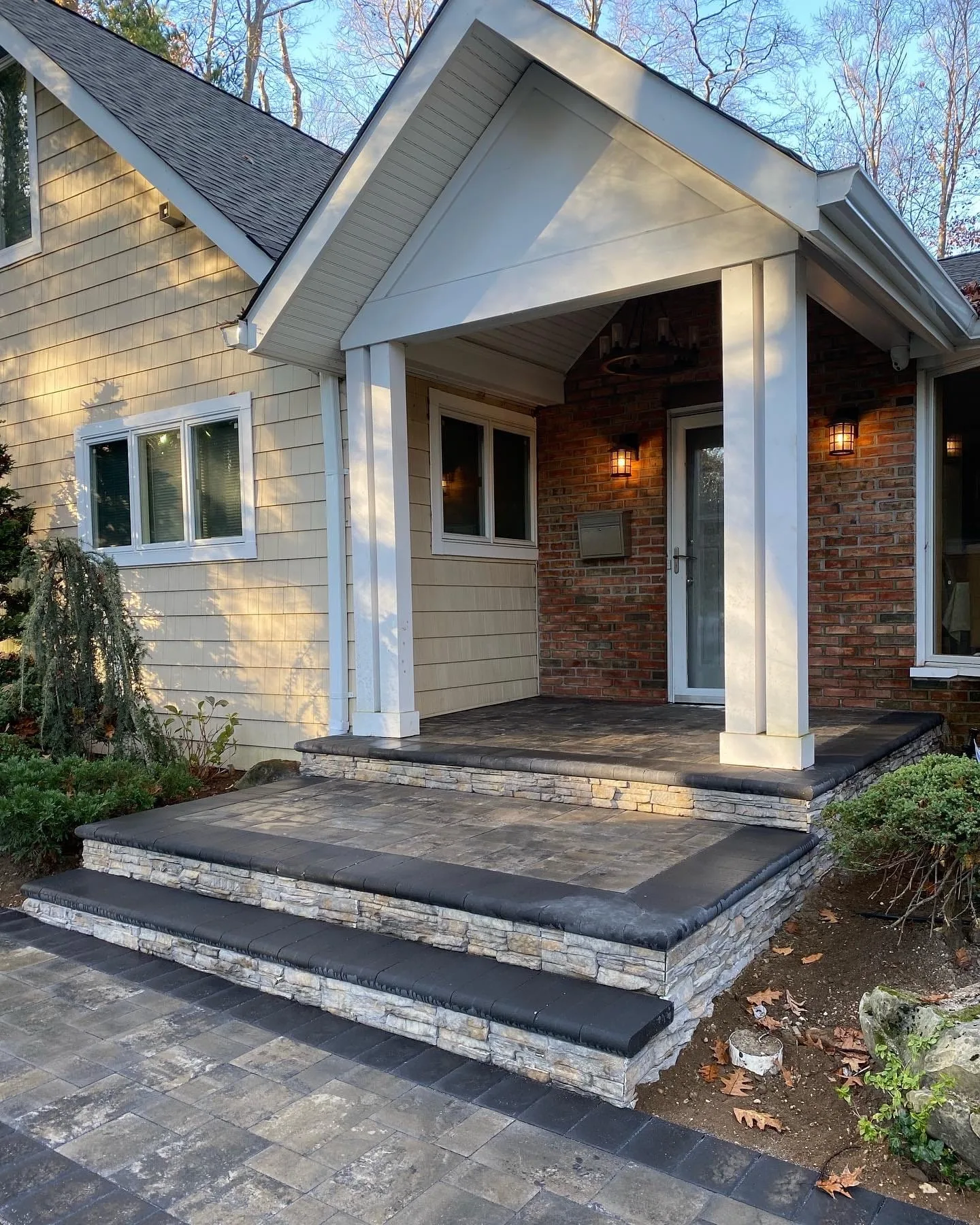 Rebuilt front stoop with natural stone veneer and aluminum railing in Bellmore, Long Island